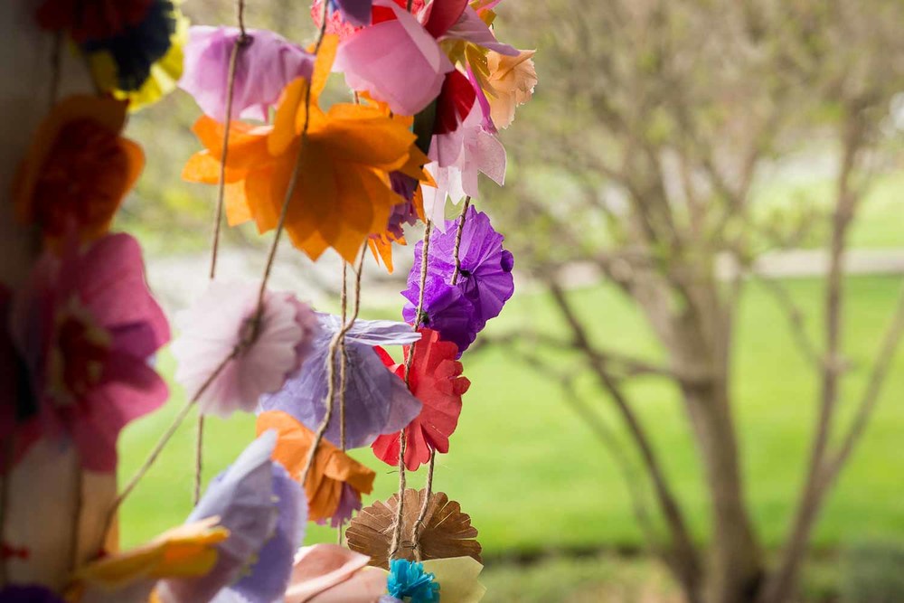 Strings of handmade paper flowers as a bright wedding decoration